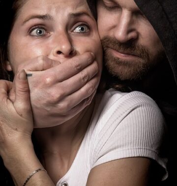 An image symbolizing intimidation and censorship, showing a man silencing a worried woman.