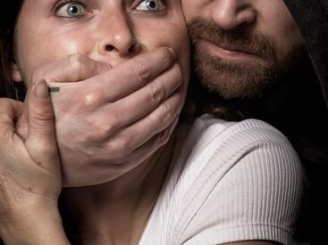 An image symbolizing intimidation and censorship, showing a man silencing a worried woman.