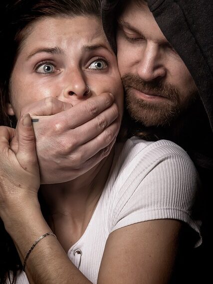 An image symbolizing intimidation and censorship, showing a man silencing a worried woman.